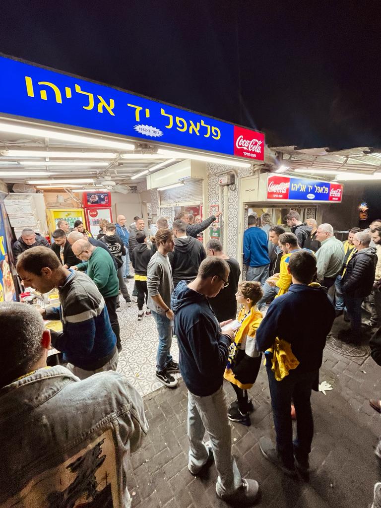 אנשים עומדים מחוץ לפלאפל "יד אליהו"