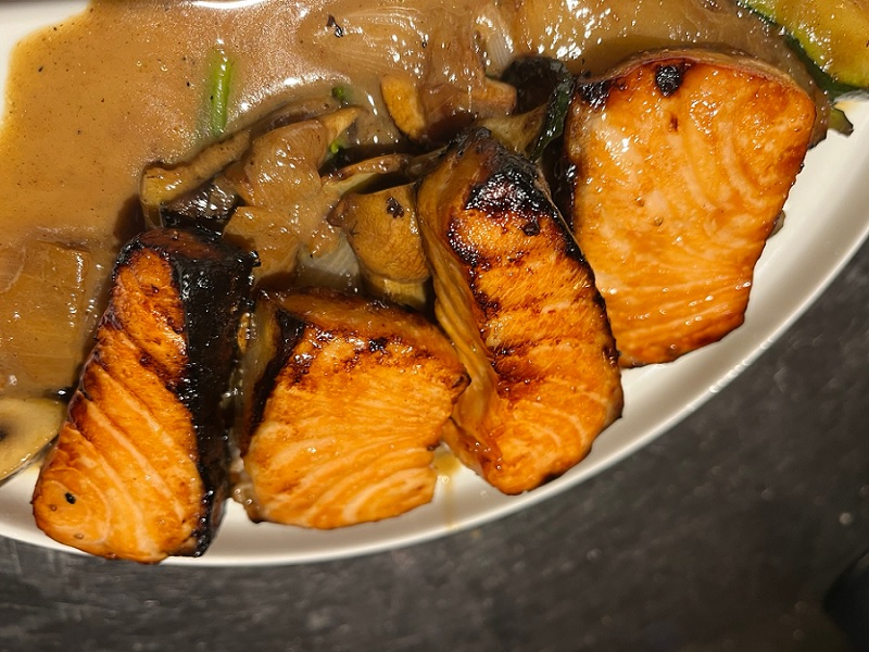 מנת דג סלמון מוגשת על צלחת לבנה במסעדת "עלמא" באשדוד