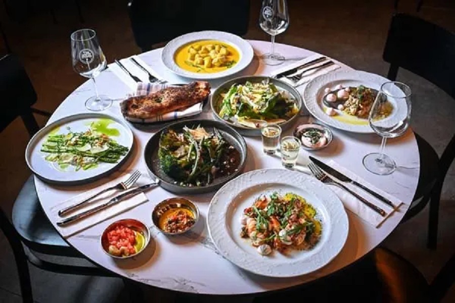 שולחן ערוך ועליו ארבע צלחות ומנות שונות במסעדה הצפונית לוסטריה