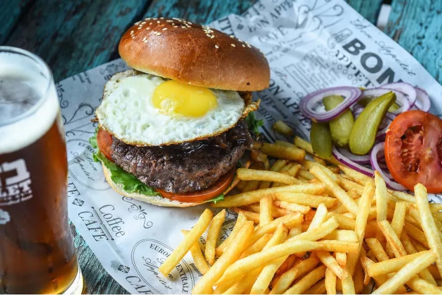 המבורגר מוגש בליווי צ'יפב ובירה במסעדה הצפונית queen's kitchen bar המבורגר מוגש בליווי צ'יפב ובירה במסעדה הצפונית queen's kitchen bar