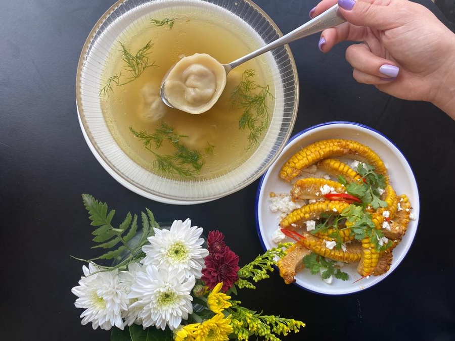 אדם אוחז בכפית ובתוכה כיסון מעל קערת מרק במסעדת Milè Mala בשוק תלפיות בחיפה