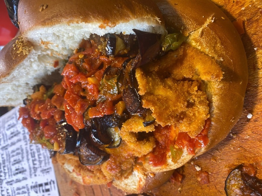 כריך שחלה פתוחה ועליו שניצל עם מטבוחה של מסעדת "ישתבח"